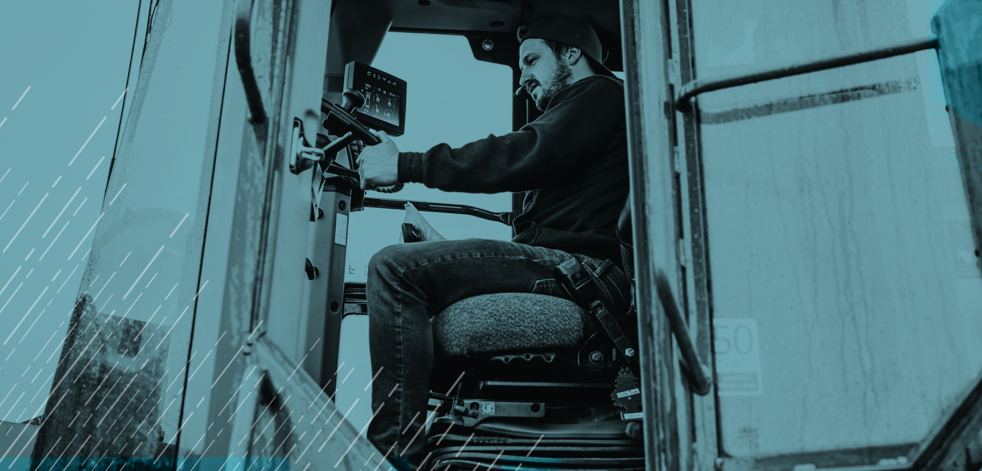 Worker sitting inside of a truck. Door is open and some computer equipment is seen